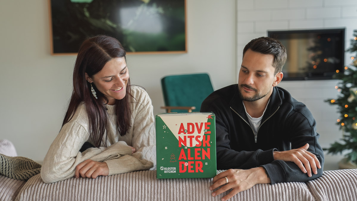 Two people looking at an advent calendar on a table.