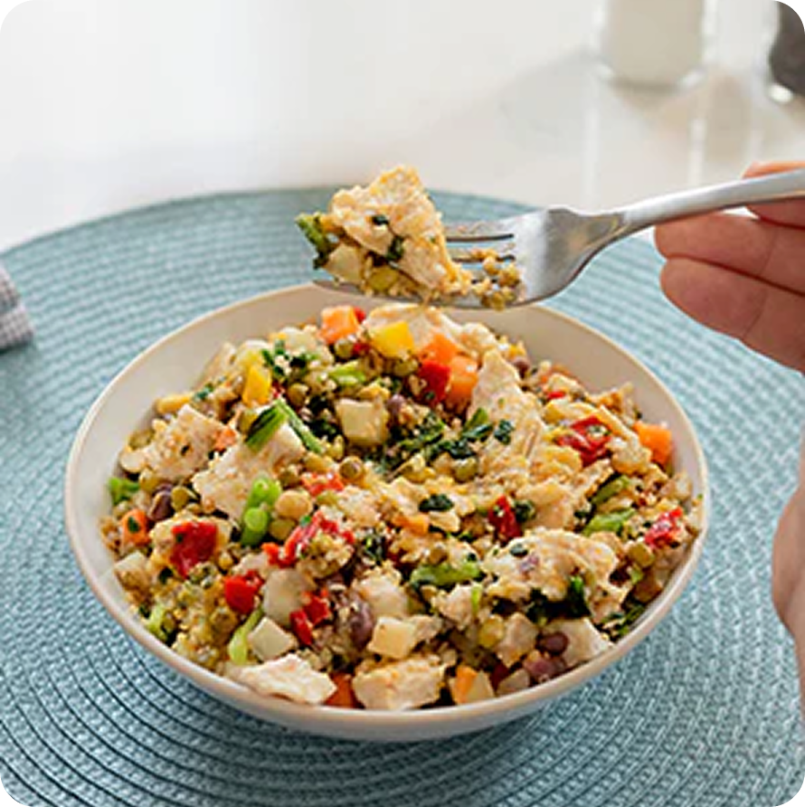 Bowl of mixed vegetables and grains with a fork scooping a bite.