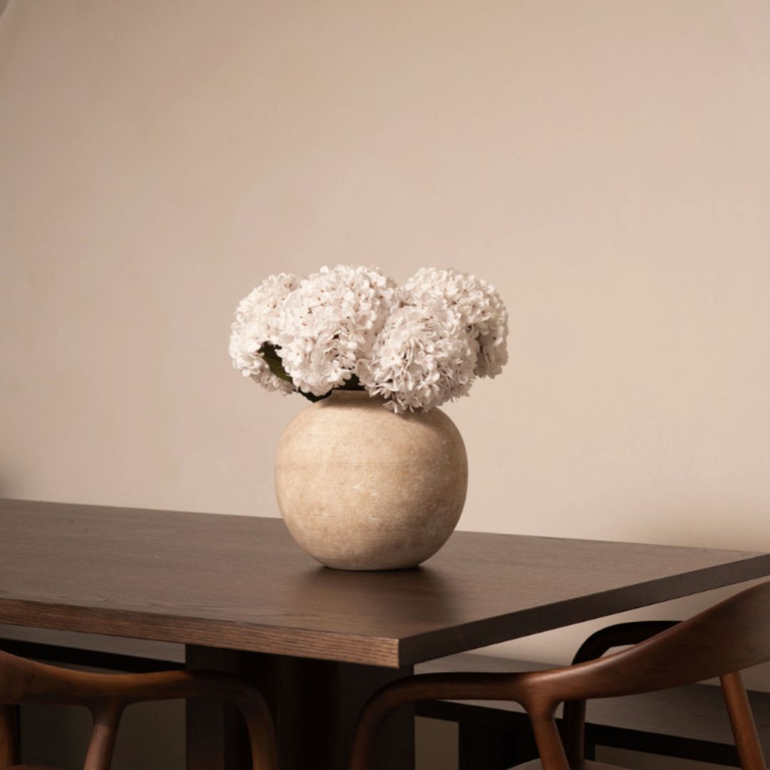 Vase with white flowers on a wooden table.