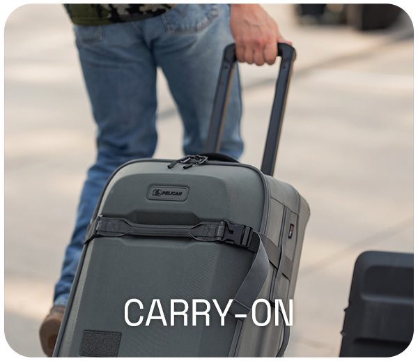 Person with rolling grey carry-on suitcase on the street.