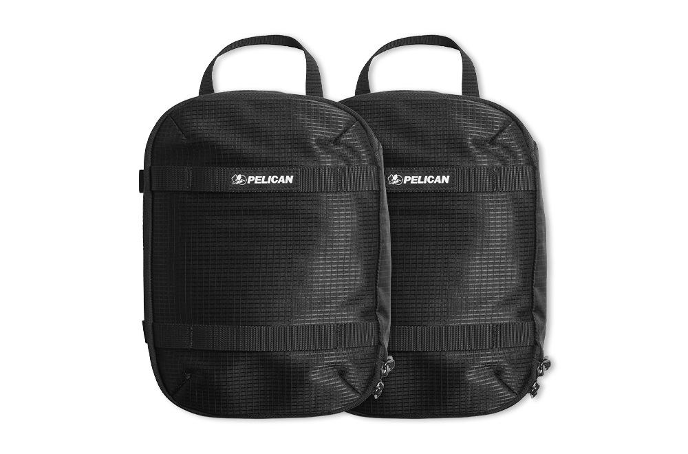 Two black Pelican backpacks with handles and grid patterns.