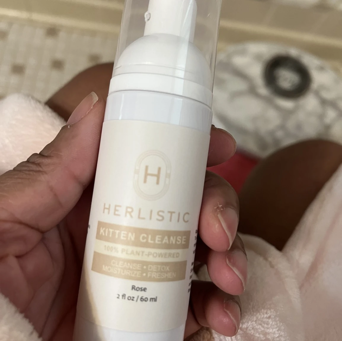 Hand holding a bottle of Herlistic Kitten Cleanse product.