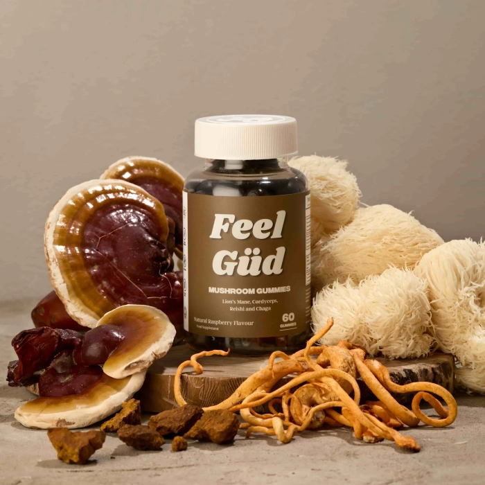 A bottle of mushroom gummies surrounded by various types of mushrooms.