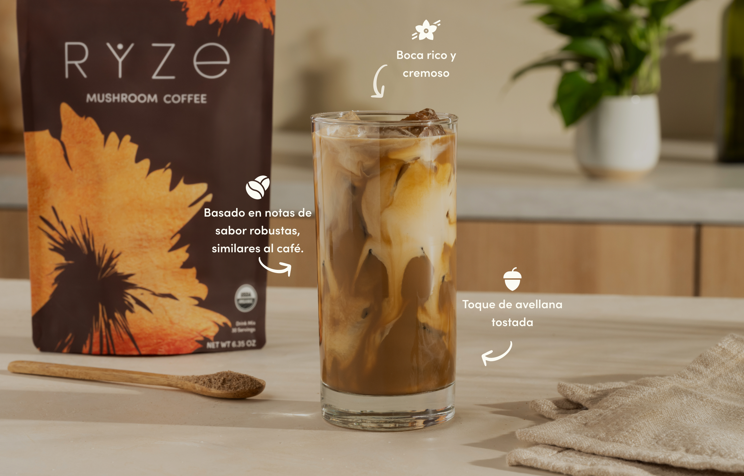 Glass of iced coffee with a bag of mushroom coffee and spoon on a table.