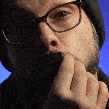 Person with glasses and beanie holding tape over mouth.