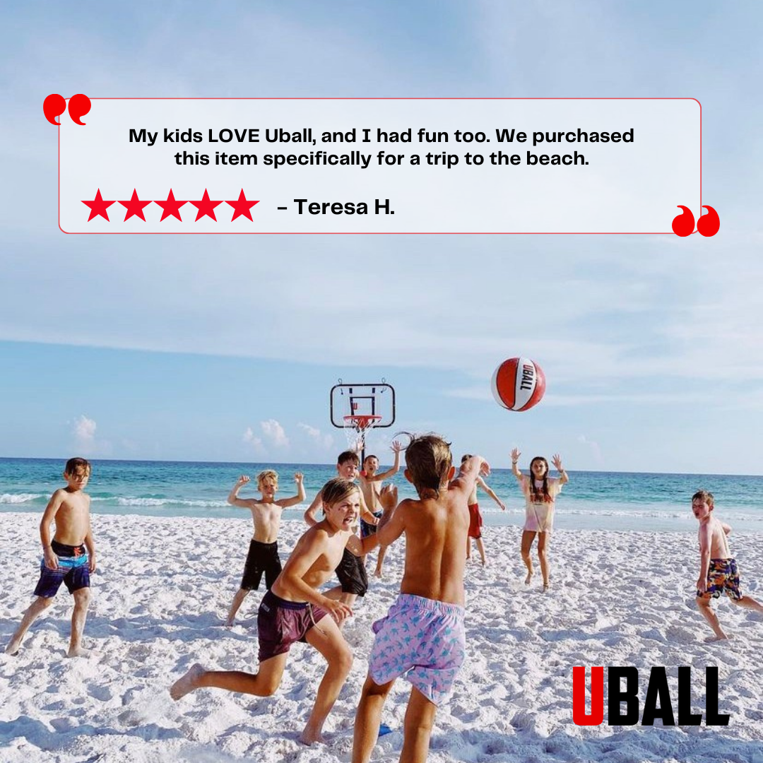 Children playing basketball on a beach with a portable hoop.