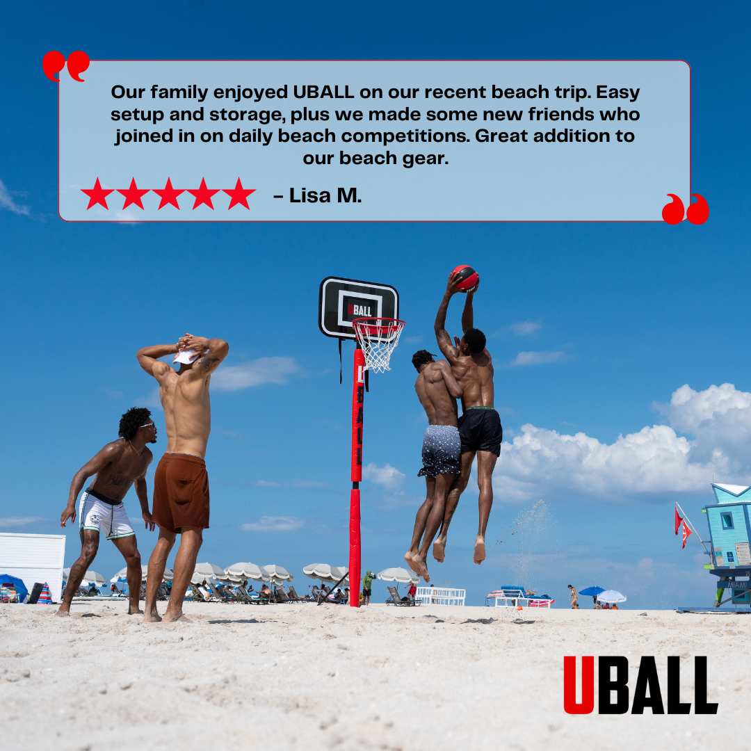 Four people playing basketball on a beach with a portable hoop.