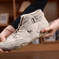 Hands holding a beige high-top sneaker with a logo on the side.
