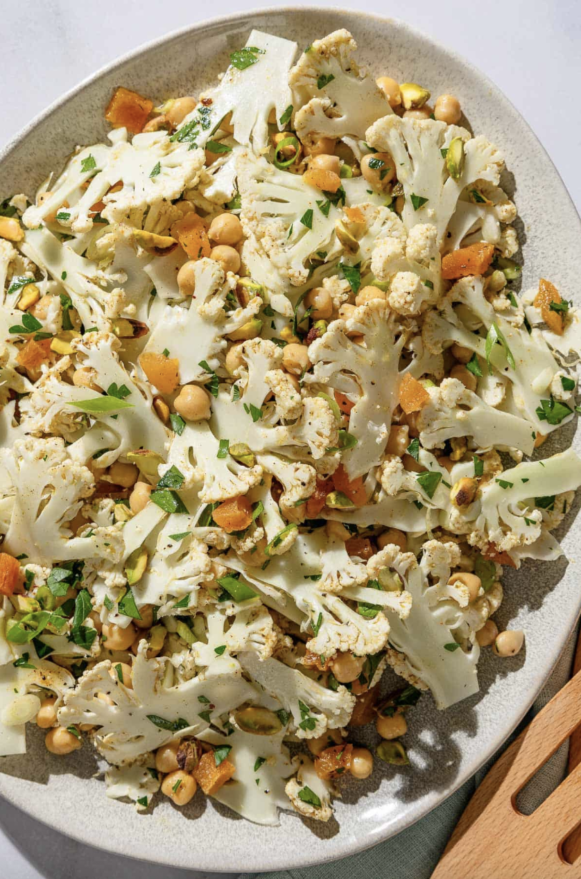 Plate of cauliflower salad with chickpeas, herbs, and nuts.