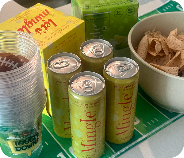 A football-themed party table with Mingle mocktails, tortilla chips, and cups.