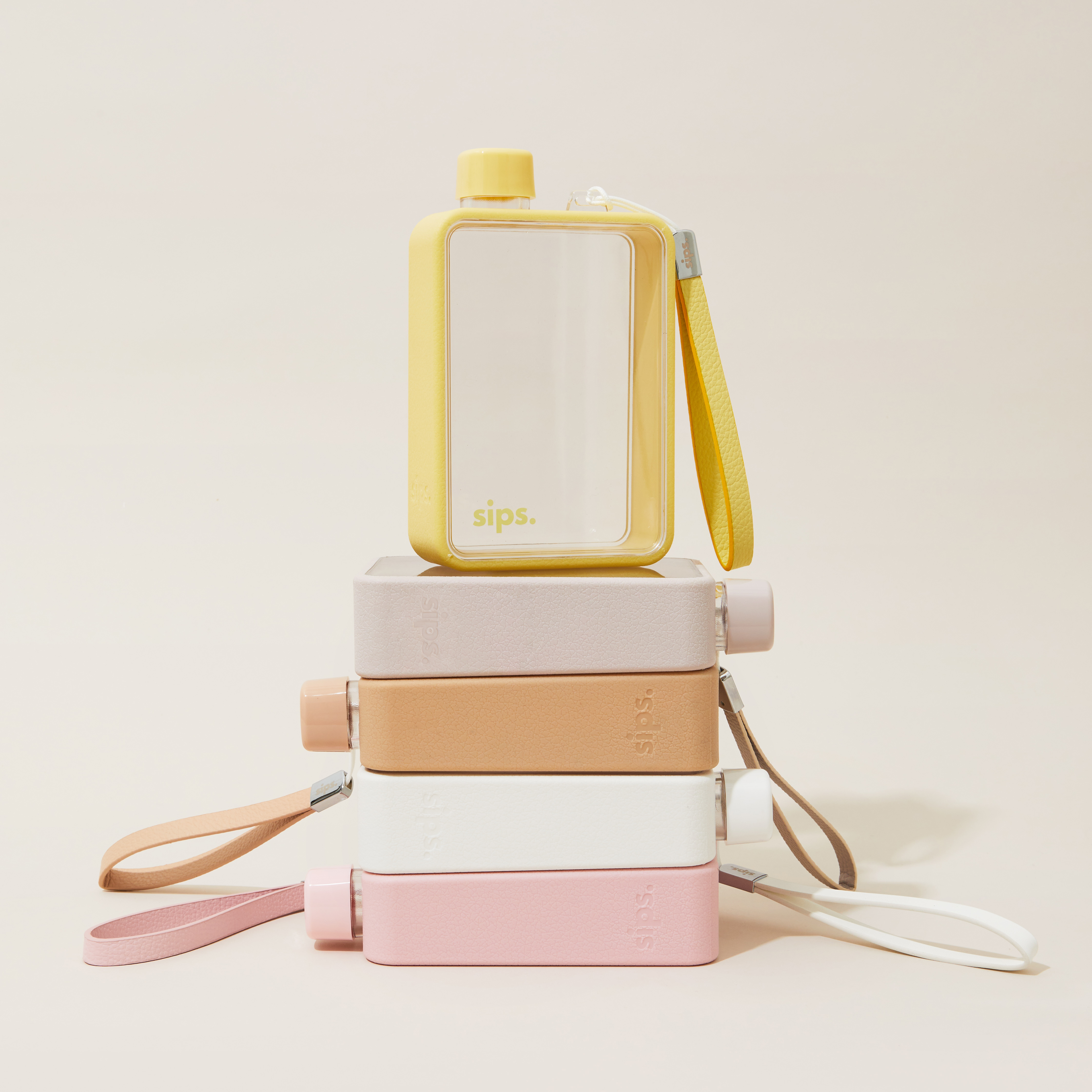 Stack of colorful flat water bottles with straps.