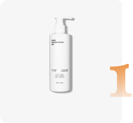 A white pump bottle of basic maintenance lab's The Face Wash next to a large orange roman numeral I.