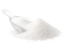 A clear scoop rests in a pile of white granulated sugar against a white background.