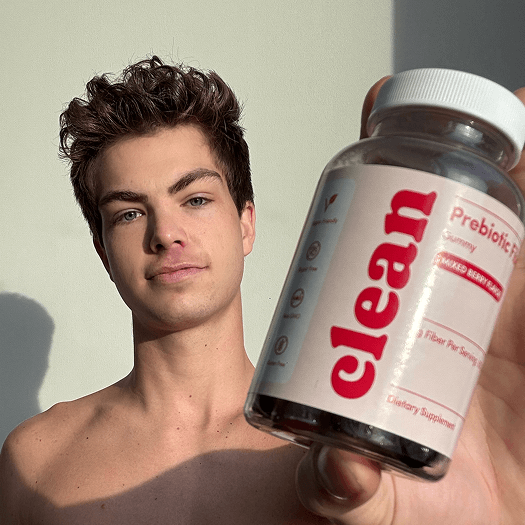 Person holding a bottle labeled 'clean' dietary supplement.