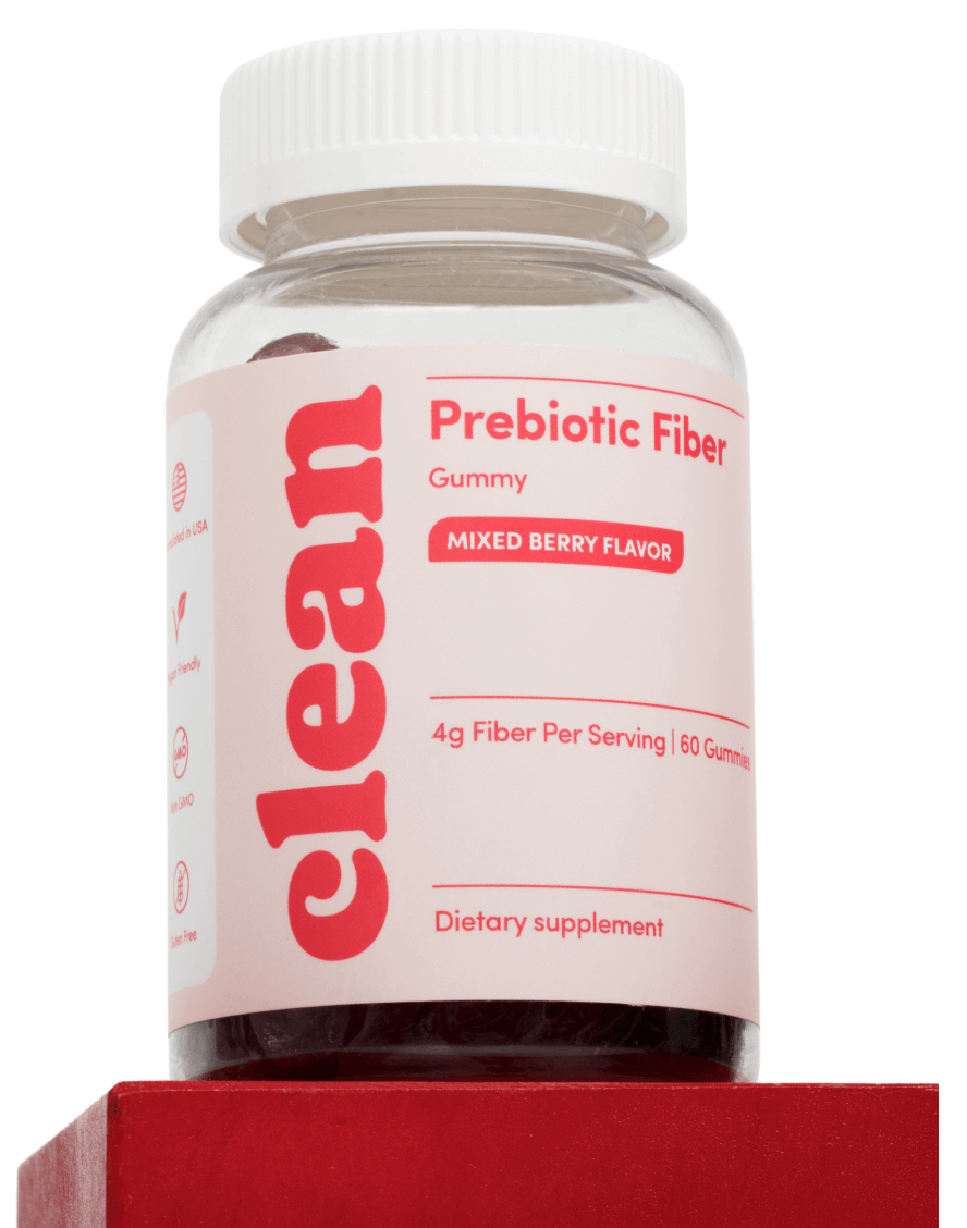 Bottle of prebiotic fiber gummies with mixed berry flavor on a red block.