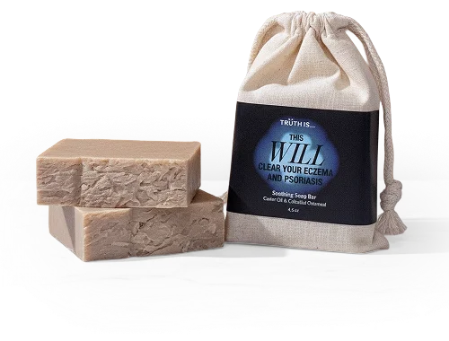 Two rectangular bars of soap are stacked next to a cloth drawstring bag with a product label.