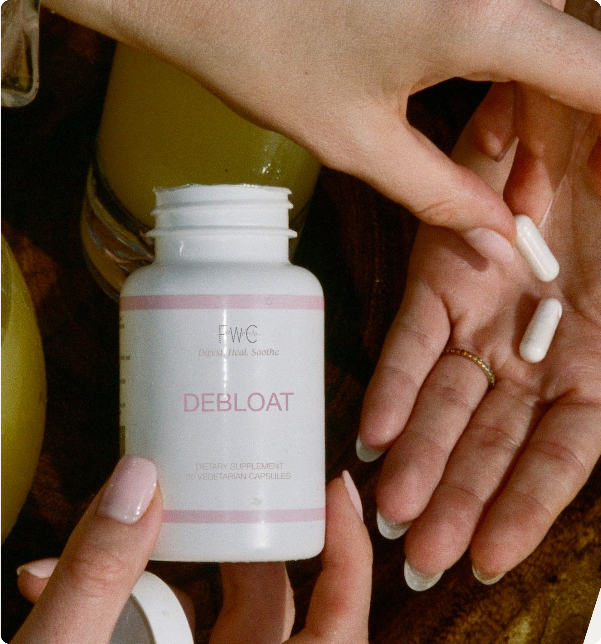 Hands holding a bottle labeled 'Debloat' and white capsules.