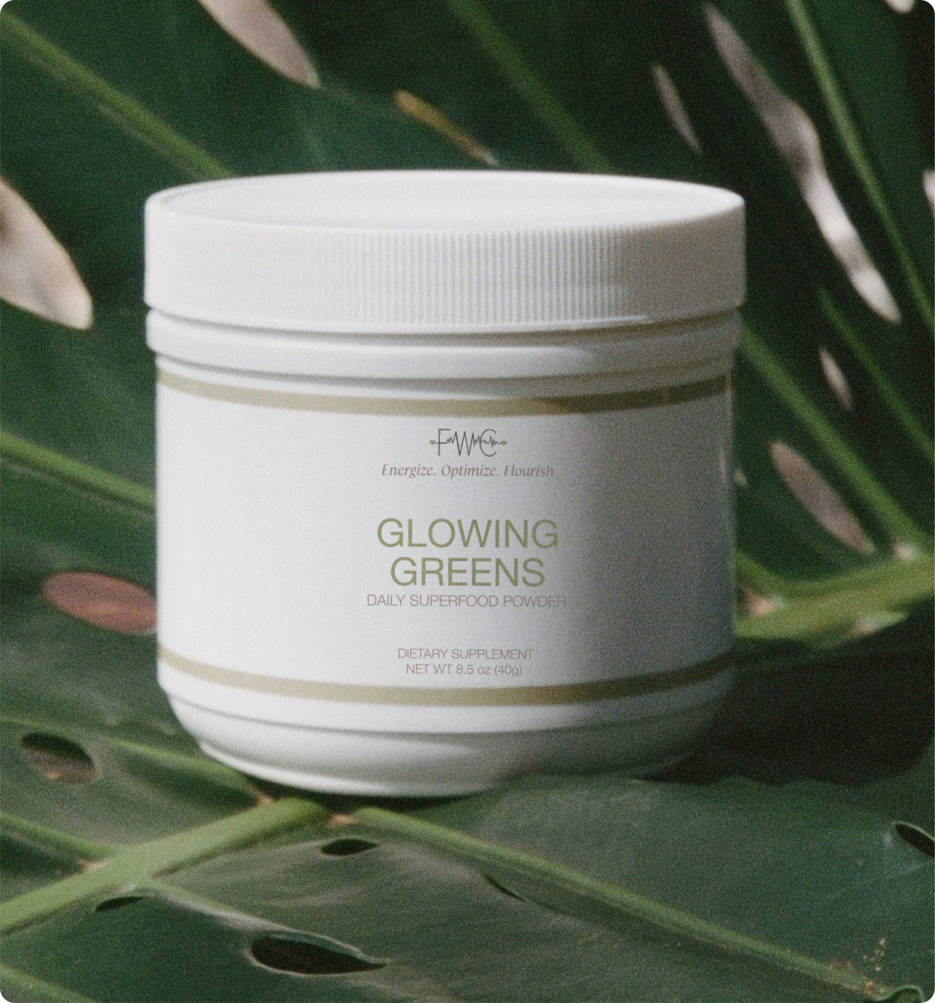 A white jar of 'Glowing Greens' superfood powder on a leafy background.