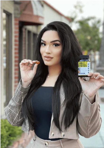 Person holding a supplement bottle and a capsule outdoors.