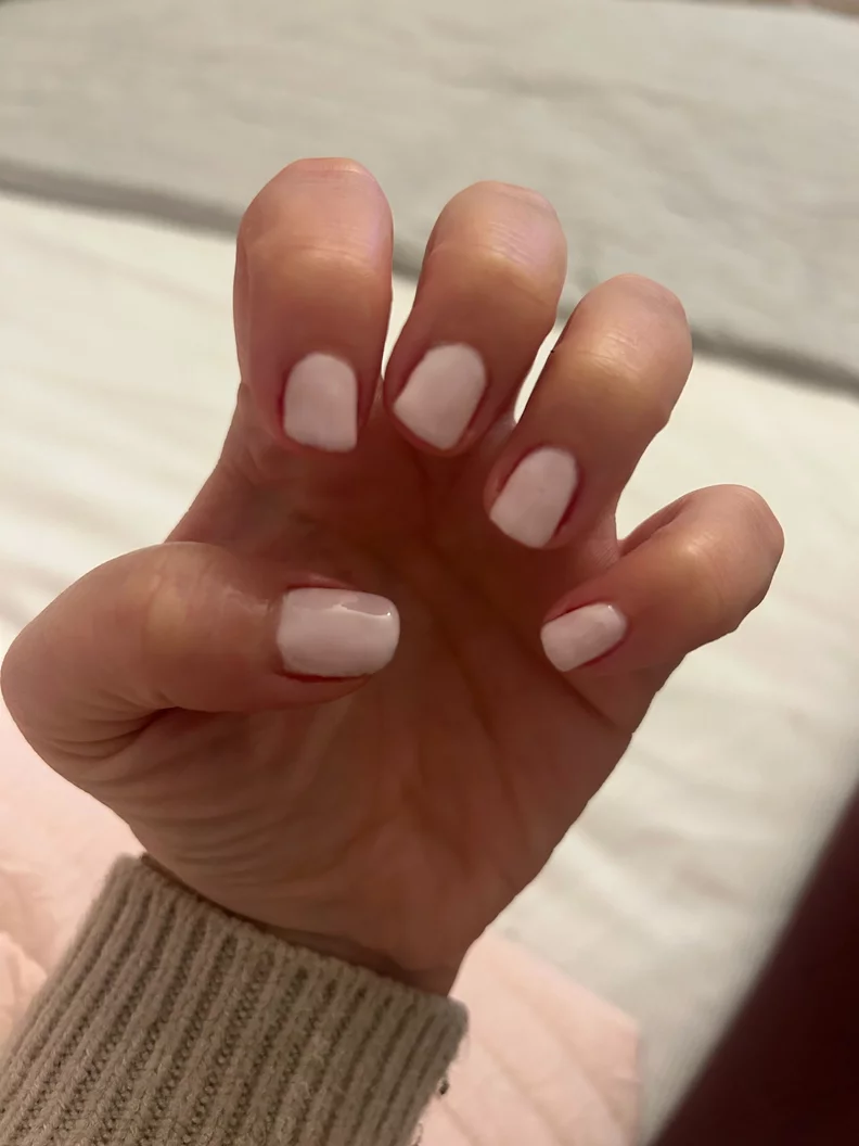 Hand with white painted nails in a relaxed pose.