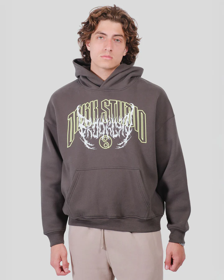 Person wearing black pants, patterned shirt, and white sneakers.