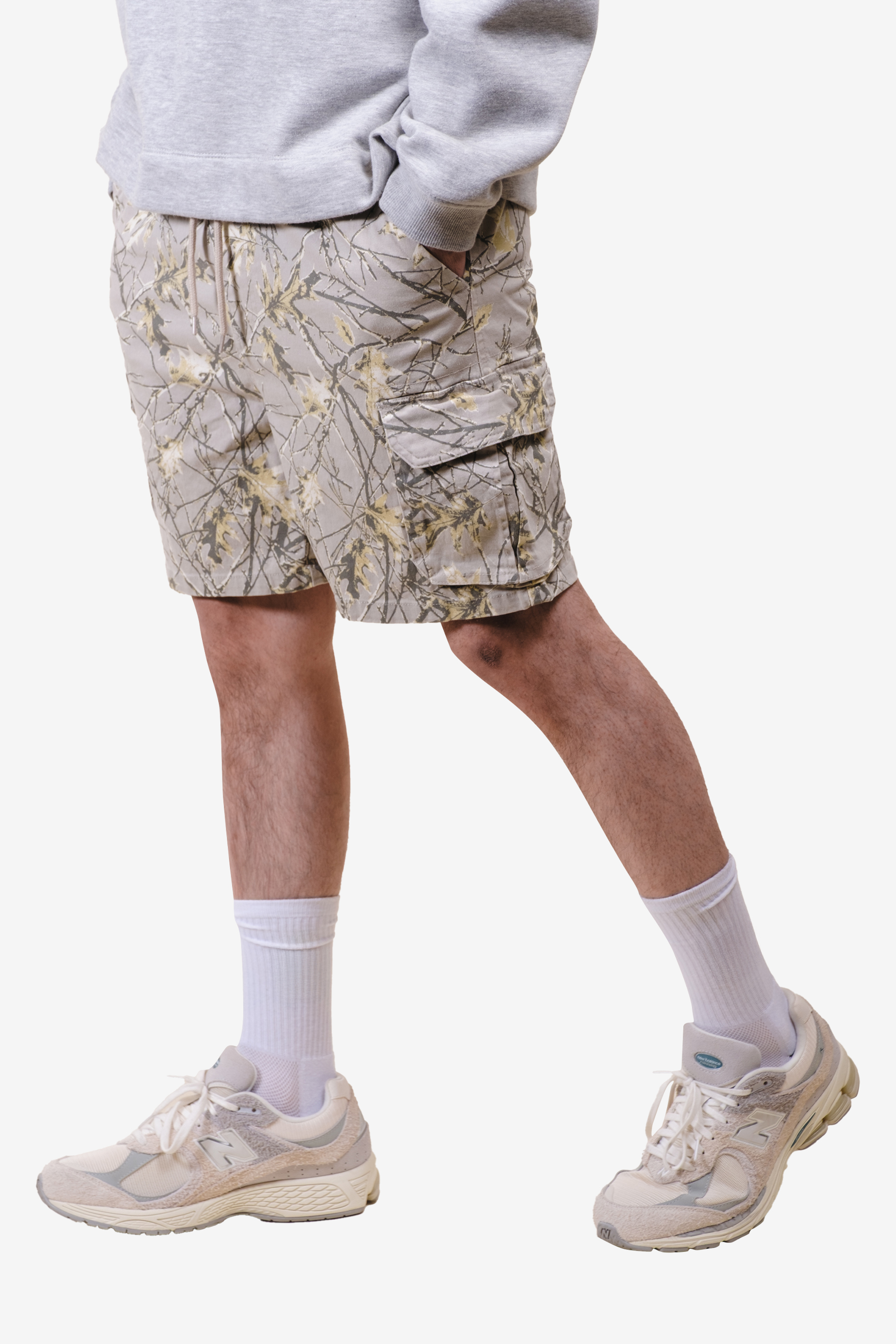 Person wearing camo cargo shorts, white socks, and sneakers.