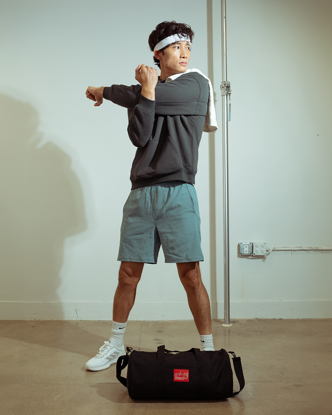 Person wearing a dark t-shirt and green pants against a white background.