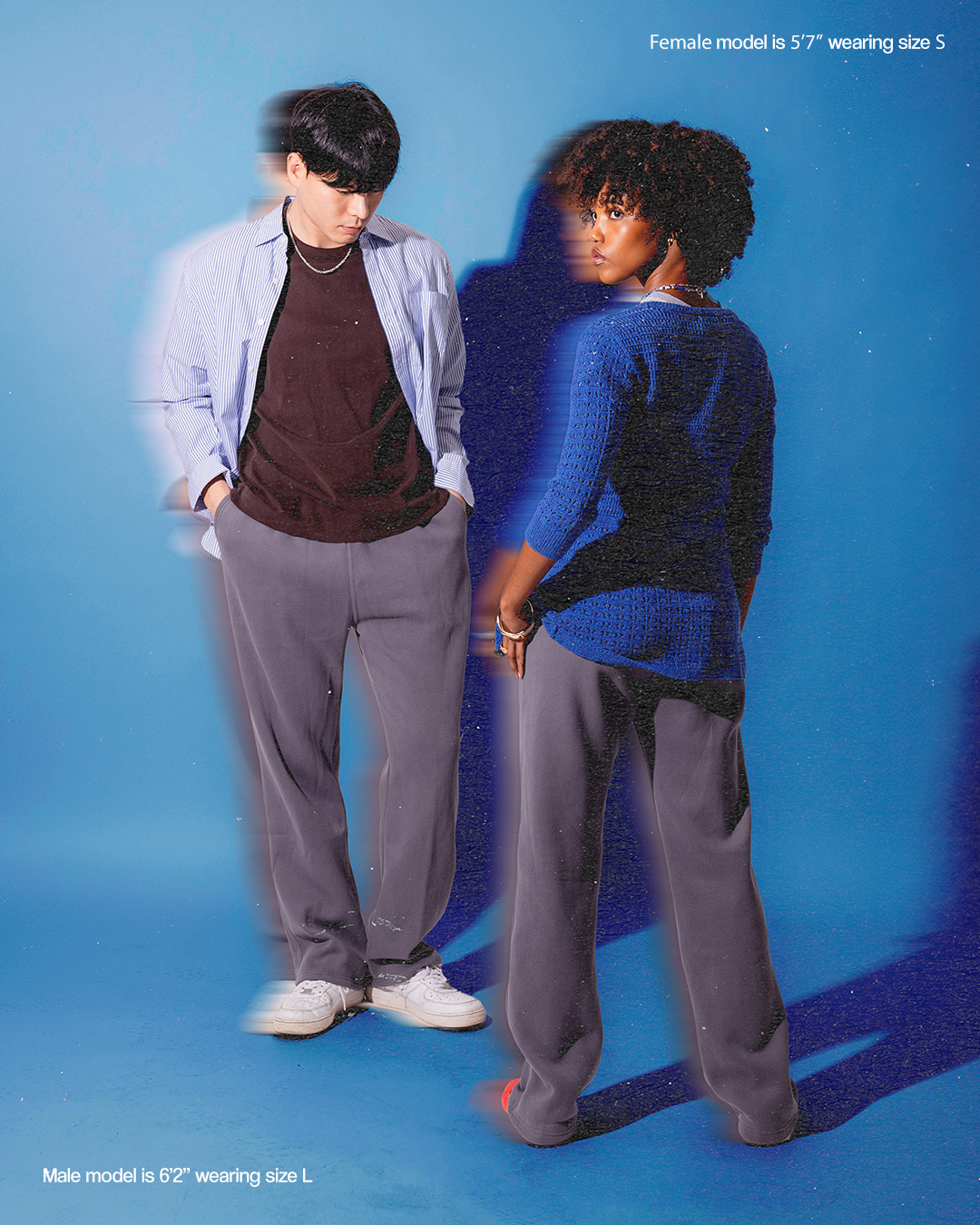 Two models standing, one facing forward, the other backward, on a blue background.
