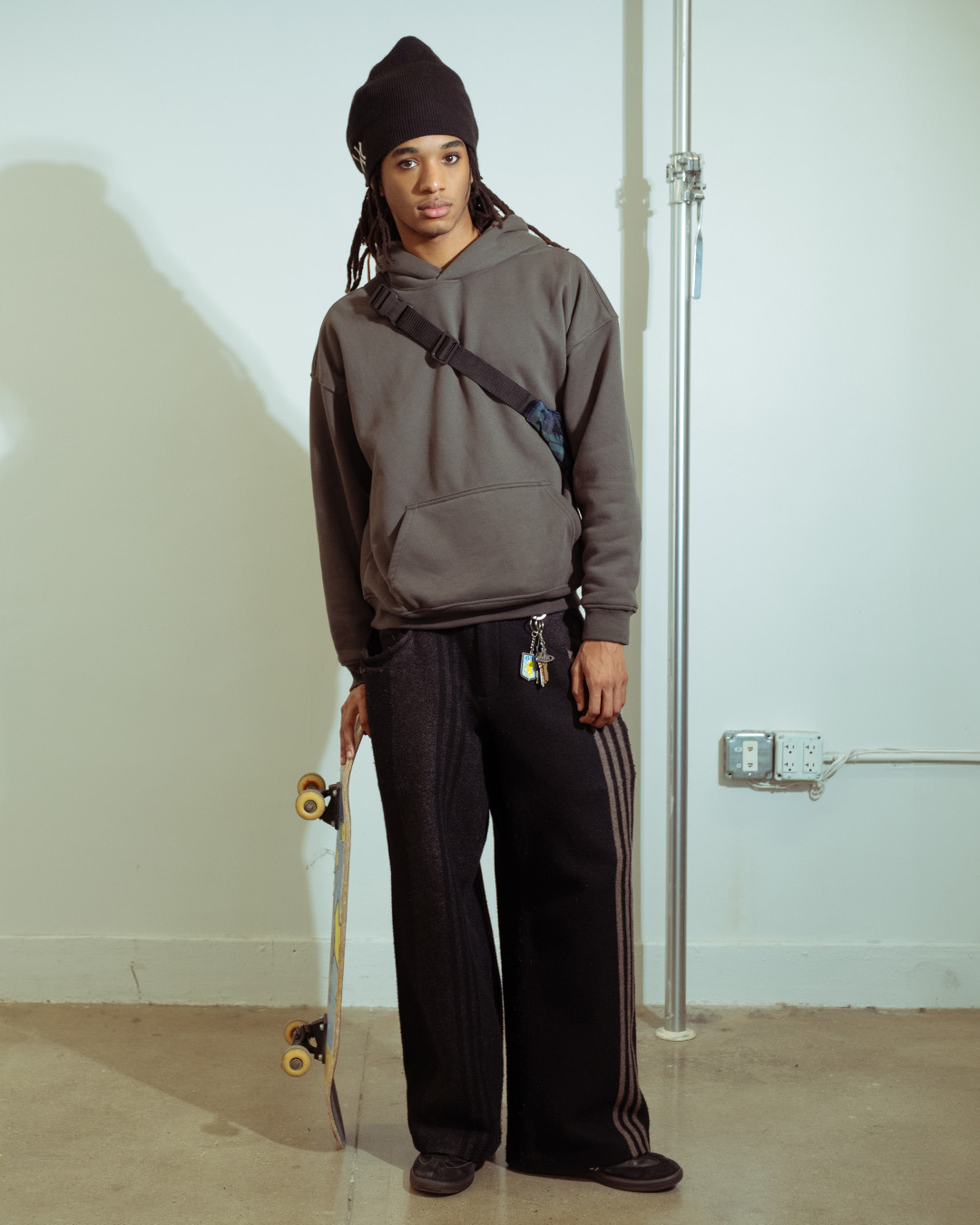 Person wearing black pants, patterned shirt, and white sneakers.