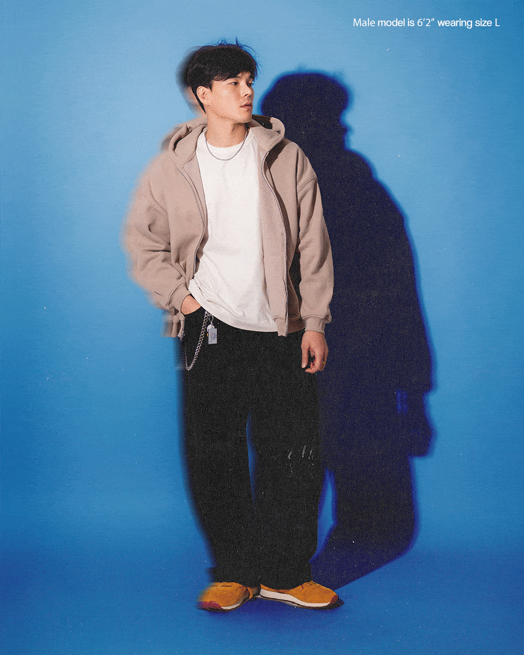 Model in casual clothing against a blue background.