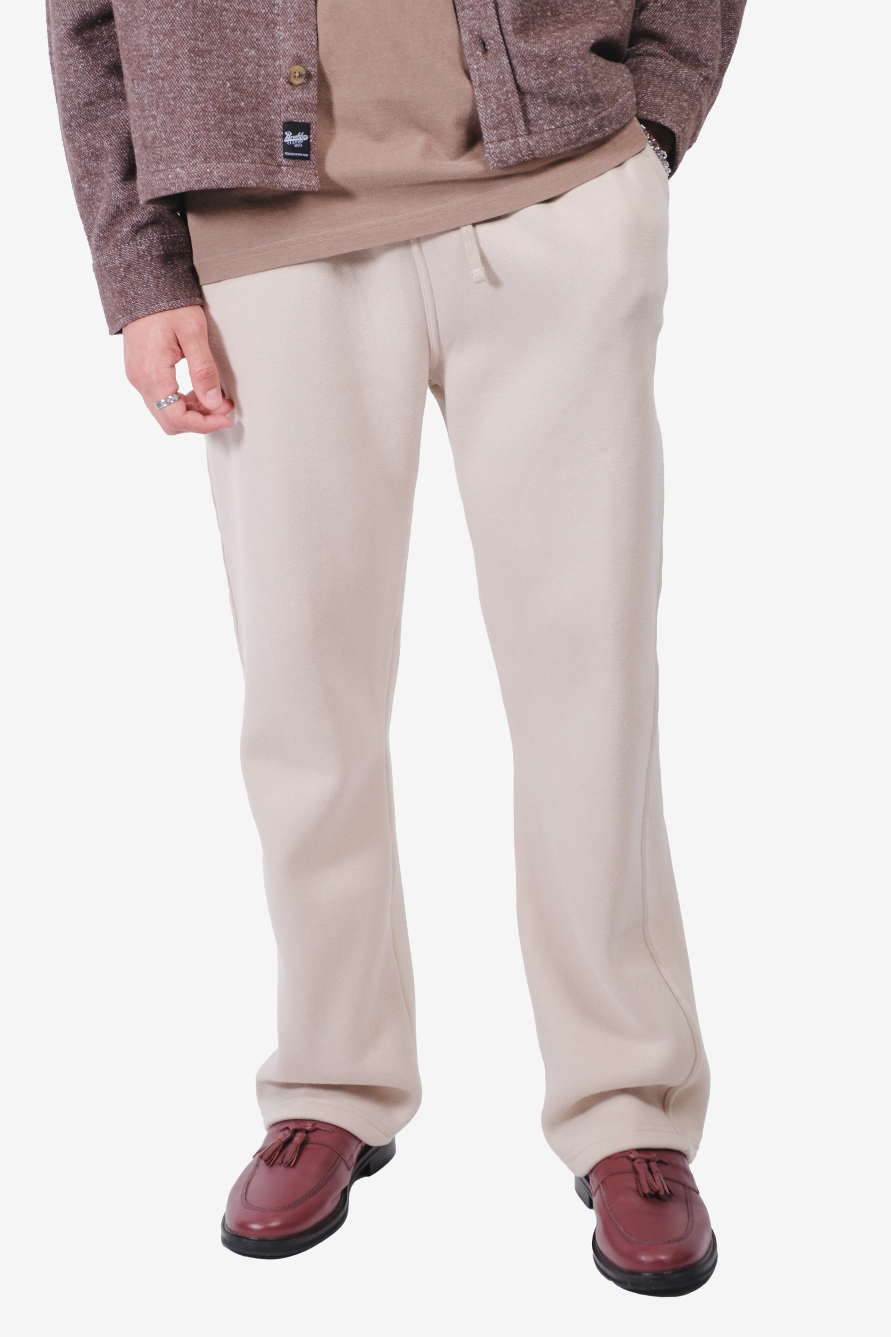 Person wearing beige pants, brown jacket, and red shoes.