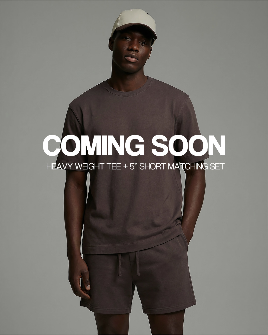 A man models a brown t-shirt and shorts set and a baseball cap, with text overlaying that reads 'Coming Soon'.