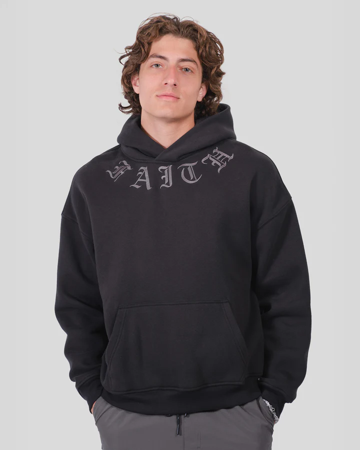 Person wearing black pants, patterned shirt, and white sneakers.