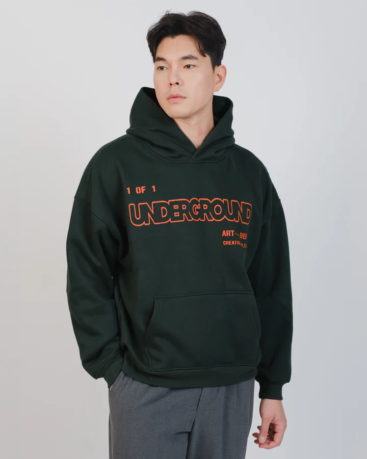 Person wearing a dark t-shirt and green pants against a white background.