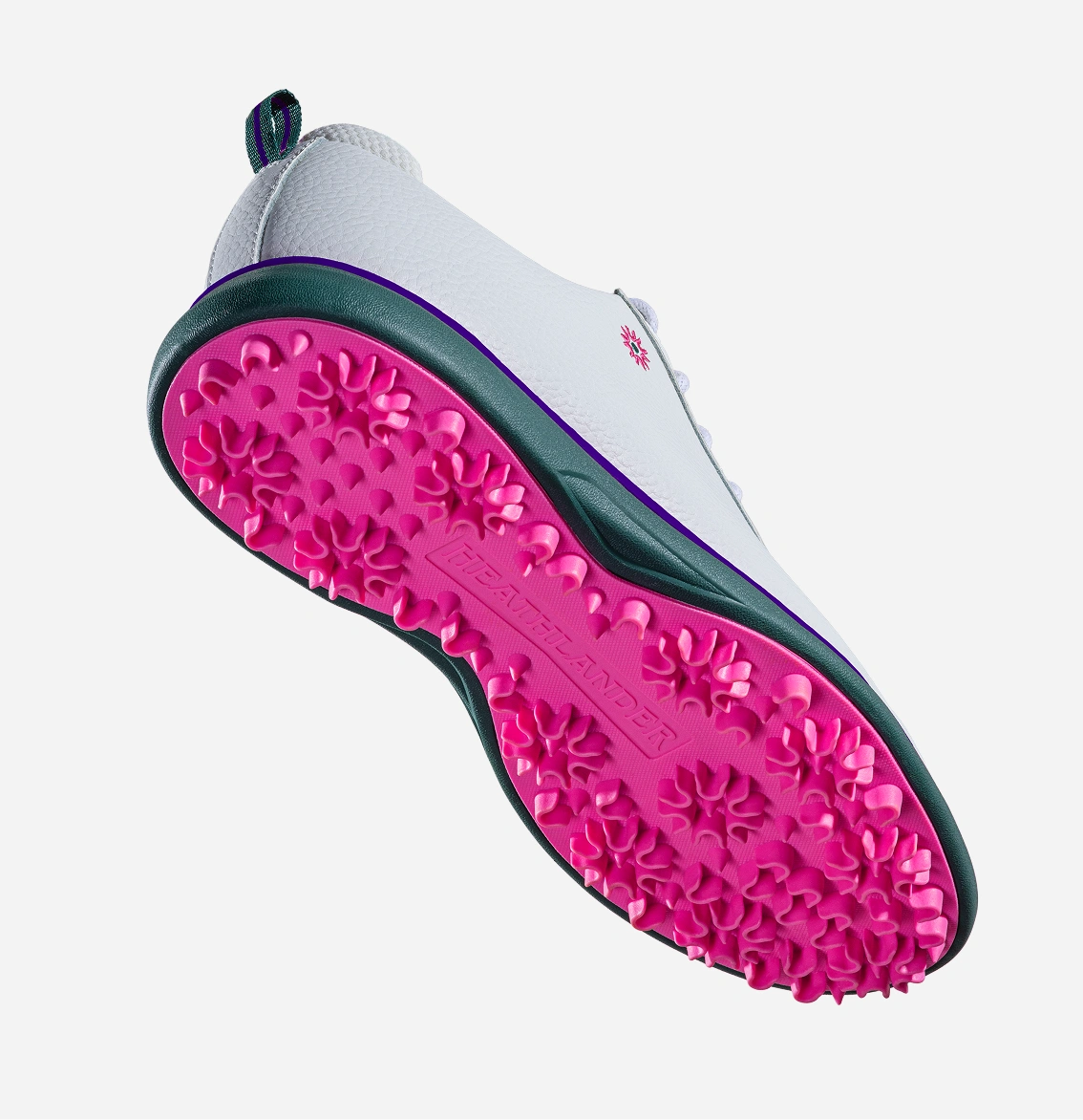 A white golf shoe with a bright pink spikeless sole and purple trim, viewed from underneath.