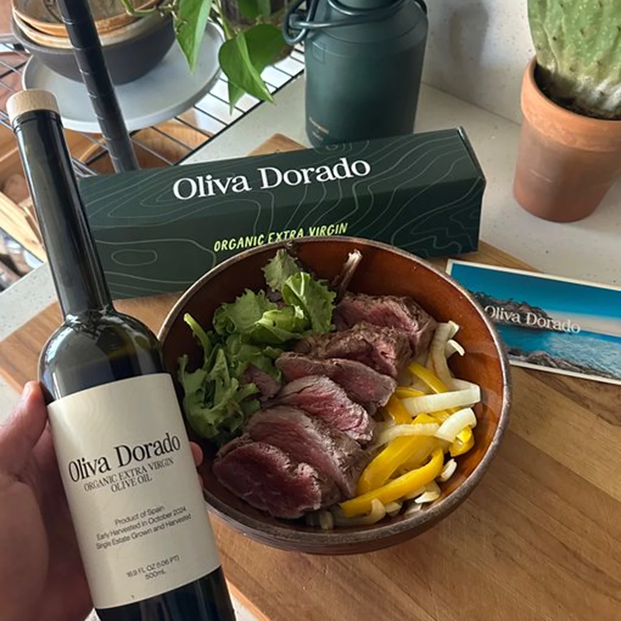 Bottle of olive oil and salad with meat, peppers, and greens.