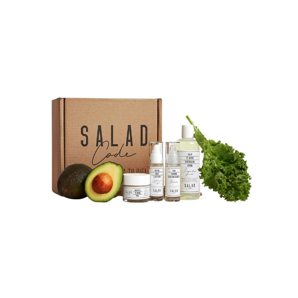 A Salad Code skincare set with a cardboard box, an avocado, and a kale leaf.