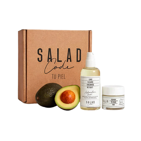 A Salad Code cosmetics box with a bottle, a jar, and fresh avocados.