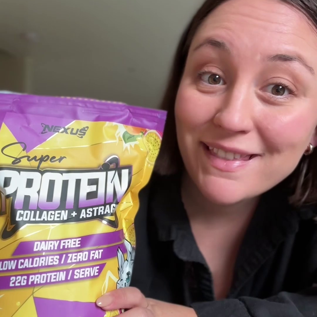 Person holding a bag of protein powder, smiling.