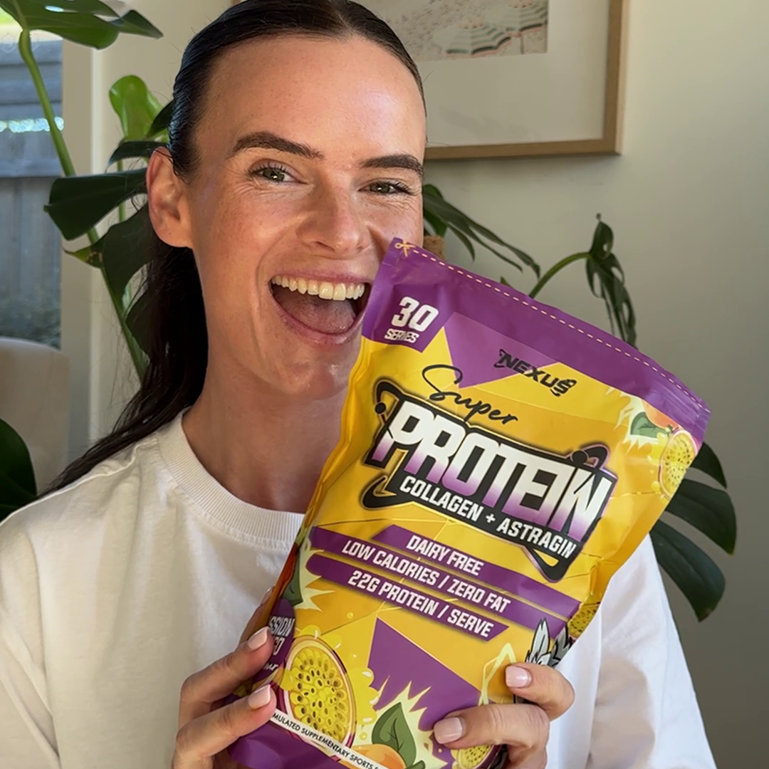 Person smiling and holding a bag of protein powder.