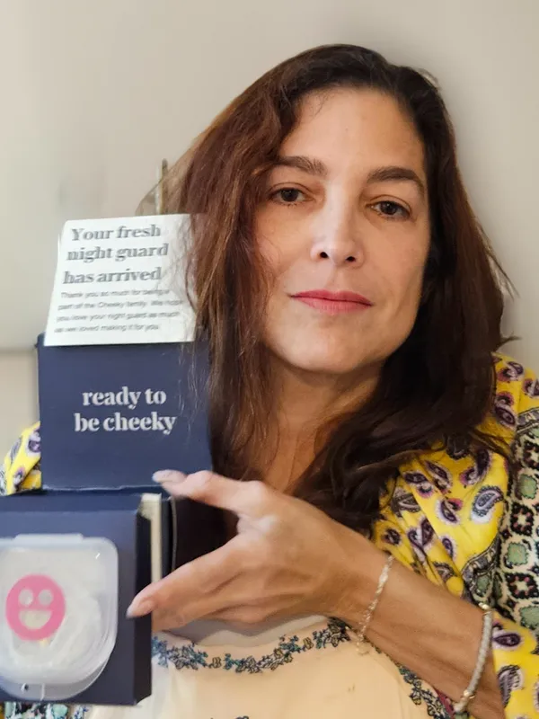 Person holding a night guard package with text 'ready to be cheeky.'