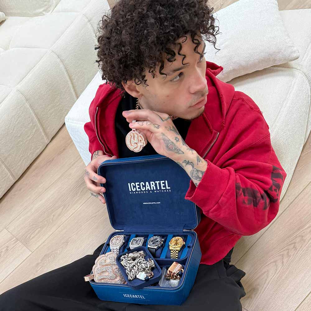 Person holding jewelry box with watches and chains inside.