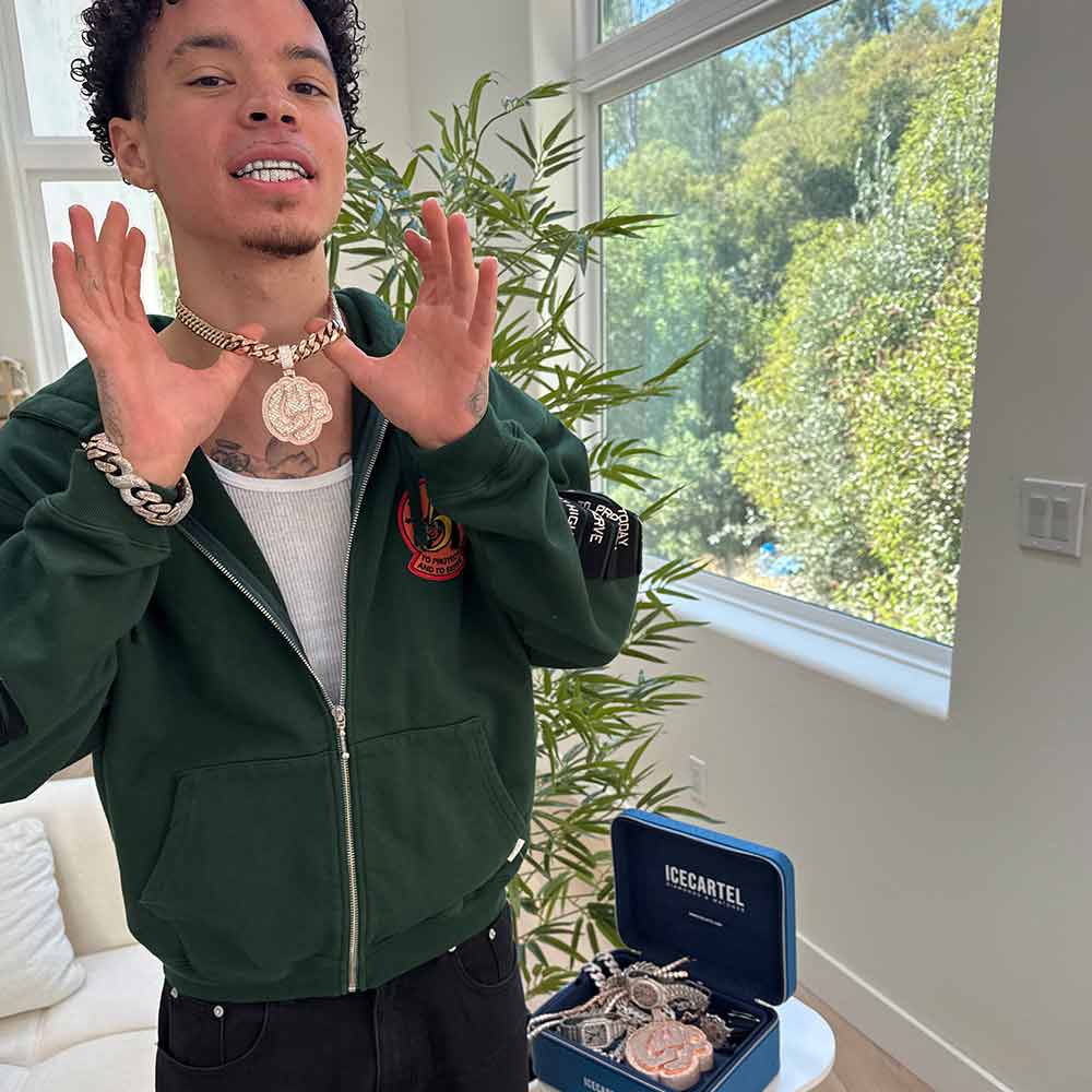 Person displaying necklace near a window with plants and jewelry box nearby.