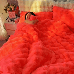 Person sleeping under fluffy, bright orange bedding in a cozy room.