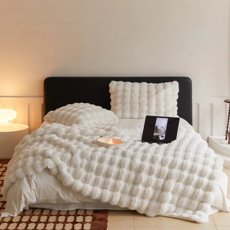 Cozy bed with fluffy white blanket, pillow, and tablet on stand.