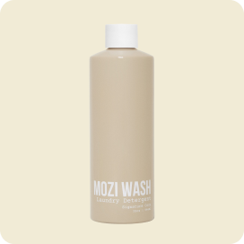 A light brown bottle of Mozi Wash laundry detergent with a white cap against a beige background.