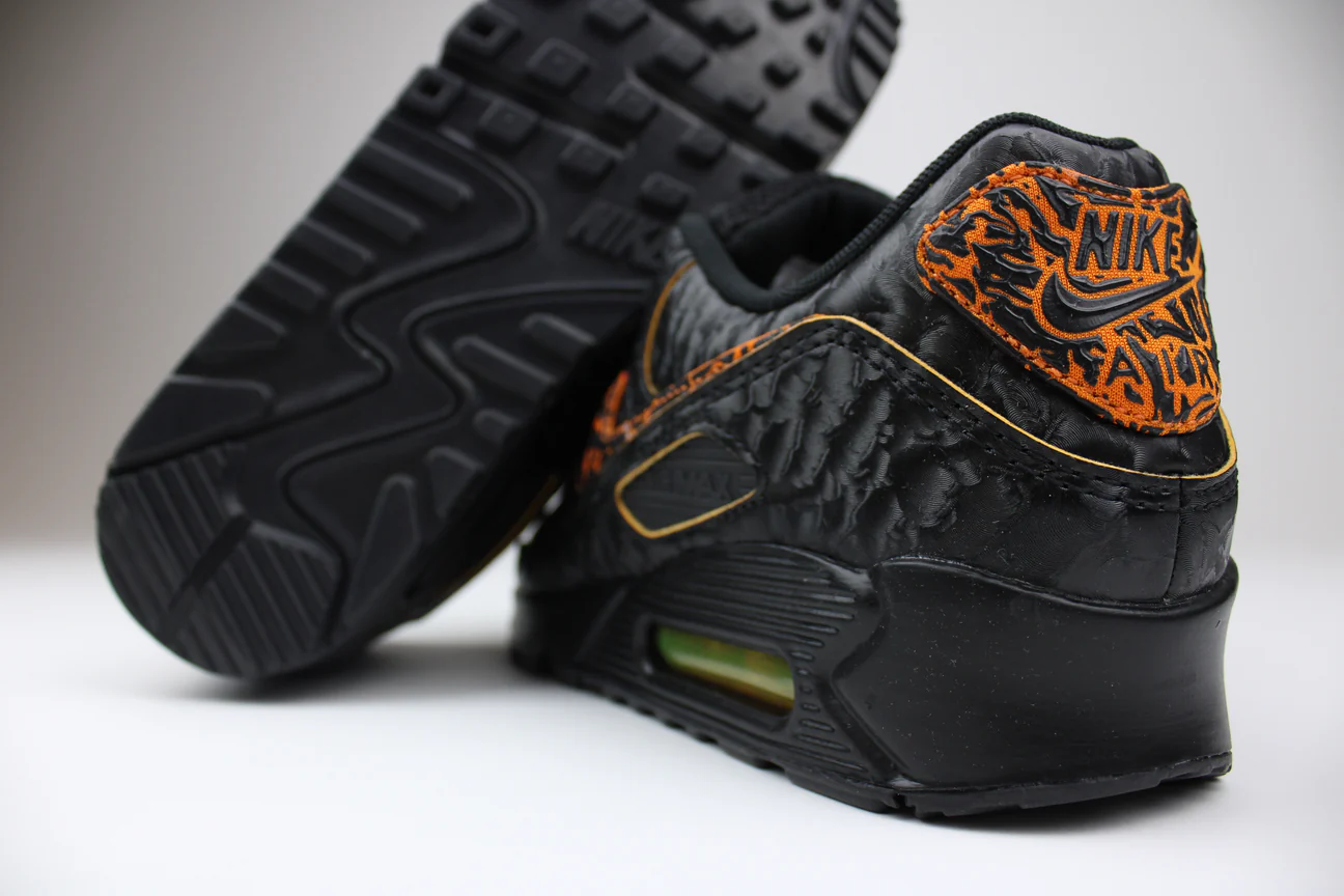 Close-up of black and orange Nike sneakers with textured design.