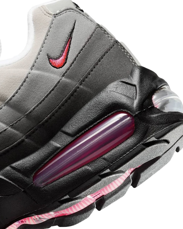 A close-up shot of the heel of a grey and black Nike sneaker with pink and red accents.