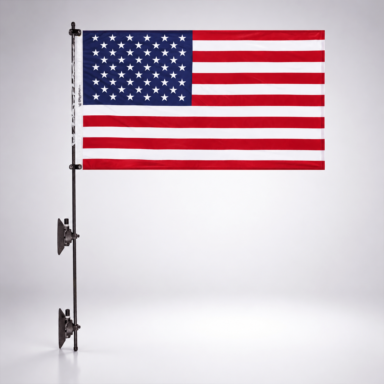 An American flag on a black pole with two suction cups against a white studio background.