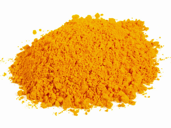 Heap of bright orange powder on white background.